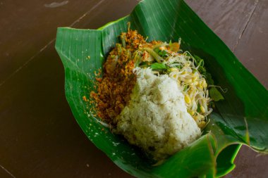 Gudangan, nasi tumpang , traditional salad food from Indonesia. Made of boiled vegetables such as, cabbage, spinach, bean sprout, long bean with peanut sauce, and grated coconut. white background