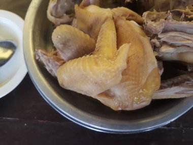 Buharda pişmiş, metal kasede küçük tabak, kaşık çatalı, ahşap arka planda izole edilmiş.