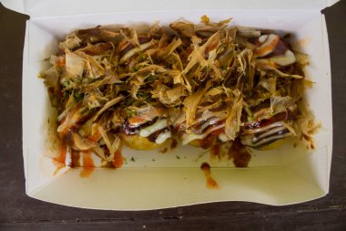 Takoyaki, Japonya 'nın ahtapot parçalarıyla dolu hamur unundan yapılmış küçük toplar şeklindeki yiyeceğidir. Japon yemekleri, ahşap arka planda izole edilmiş.
