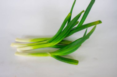 Beyaz arka planda çiğ organik pırasa ve pırasa.