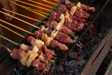 Sate kambing ya da sate klatak ya da kuzu satay ya da keçi eti satay dilimlenmiş lahana, kırmızı soğan, kırmızı biber, soya soslu domates ile servis edilir. izole edilmiş beyaz arkaplan 