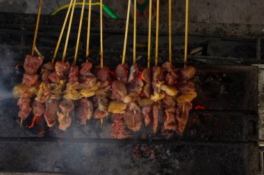 Sate kambing ya da sate klatak ya da kuzu satay ya da keçi eti satay dilimlenmiş lahana, kırmızı soğan, kırmızı biber, soya soslu domates ile servis edilir. izole edilmiş beyaz arkaplan 