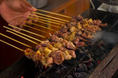 Sate kambing ya da sate klatak ya da kuzu satay ya da keçi eti satay dilimlenmiş lahana, kırmızı soğan, kırmızı biber, soya soslu domates ile servis edilir. izole edilmiş beyaz arkaplan 