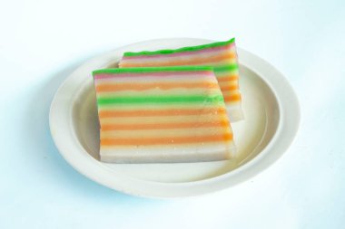 lapis cake or roti lapis or layer cake or lapis legit served in little plate isolated on white background made from rice flour, starch, coconut milk, sugar, salt and coloring