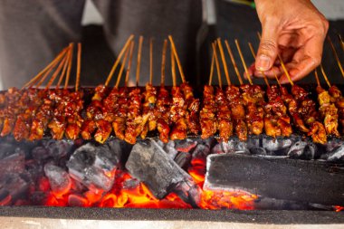 Fıstık sosu, dilimlenmiş biber ve arpacık soğanı ile servis edilen pirinç keki (lontong) ile saate ayam veya tavuk satay. resim seçici odak ile