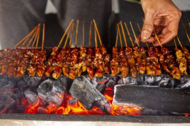Fıstık sosu, dilimlenmiş biber ve arpacık soğanı ile servis edilen pirinç keki (lontong) ile saate ayam veya tavuk satay. resim seçici odak ile