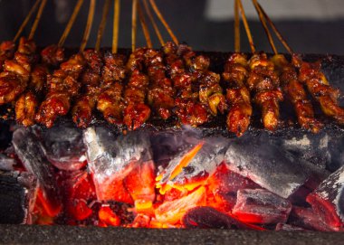 Fıstık sosu, dilimlenmiş biber ve arpacık soğanı ile servis edilen pirinç keki (lontong) ile saate ayam veya tavuk satay. resim seçici odak ile