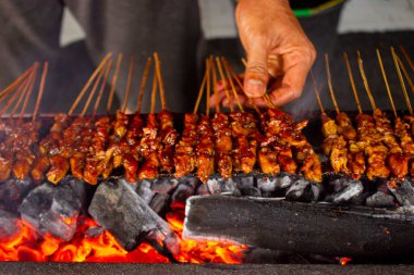 Fıstık sosu, dilimlenmiş biber ve arpacık soğanı ile servis edilen pirinç keki (lontong) ile saate ayam veya tavuk satay. resim seçici odak ile