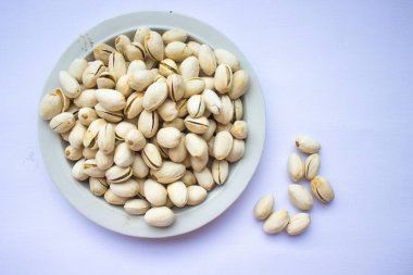 Beyaz plakalı fıstıklar beyaz arka planda izole edilmiş. Dikdörtgen şekilli fıstıklar.