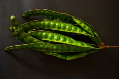 Petai, bükülmüş fasulye, Kokuşmuş fasulye, Bitter Bean, Parkia Specosa tohumları, siyah arka planda izole edilmiş.