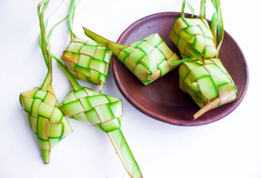Toprak kaplamalı ketupat beyaz arka planda izole edilmiş. Ketupat (Rice Dumpling), Endonezya 'daki idhul fitri (Kurban Bayramı) zamanında Hindistan cevizi yapraklarına sarılmış pirinç (janur) ile servis edilen yemektir.)