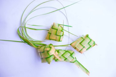 Toprak kaplamalı ketupat beyaz arka planda izole edilmiş. Ketupat (Rice Dumpling), Endonezya 'daki idhul fitri (Kurban Bayramı) zamanında Hindistan cevizi yapraklarına sarılmış pirinç (janur) ile servis edilen yemektir.)