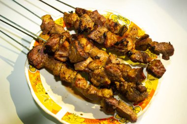 Sate kambing ya da sate klatak ya da kuzu satay ya da keçi eti satay dilimlenmiş lahana, kırmızı soğan, kırmızı biber, soya soslu domates ile servis edilir. izole edilmiş beyaz arkaplan Endonezyası