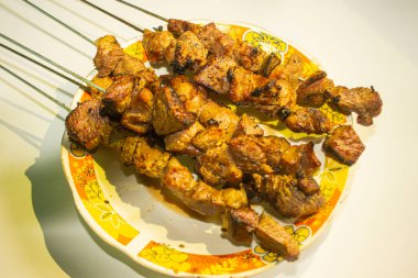 Sate kambing ya da sate klatak ya da kuzu satay ya da keçi eti satay dilimlenmiş lahana, kırmızı soğan, kırmızı biber, soya soslu domates ile servis edilir. izole edilmiş beyaz arkaplan Endonezyası