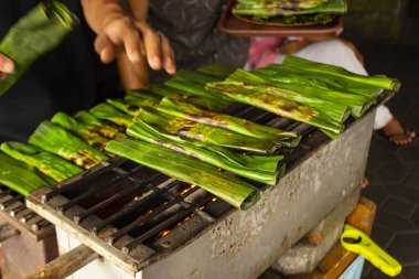otak - otak is a food made from minced mackerel fish meat wrapped in banana leaves, baked, and served with spicy and sour sauce. otak-otak is traditional fish cake from indonesia