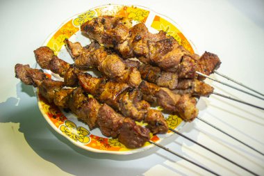 Sate kambing ya da sate klatak ya da kuzu satay ya da keçi eti satay dilimlenmiş lahana, kırmızı soğan, kırmızı biber, soya soslu domates ile servis edilir. izole edilmiş beyaz arkaplan Endonezyası