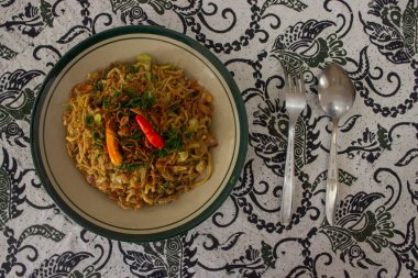 Mie Goreng Jawa ya da bakmi jawa ya da çatal kaşıklı Java noodle. Endonezya geleneksel sokak eriştesi Orta Java ya da Yogyakarta, Endonezya ahşap arka planda.