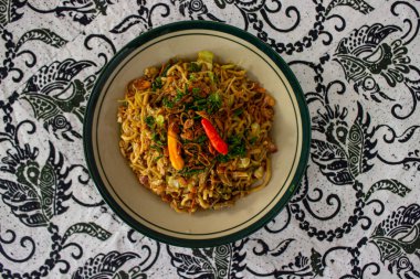 Mie Goreng Jawa ya da bakmi jawa ya da çatal kaşıklı Java noodle. Endonezya geleneksel sokak eriştesi Orta Java ya da Yogyakarta, Endonezya ahşap arka planda.
