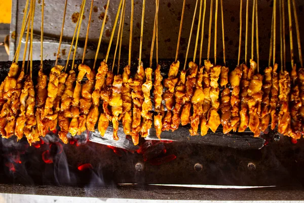 Fıstık sosu, dilimlenmiş biber ve arpacık soğanı ile servis edilen pirinç keki (lontong) ile saate ayam veya tavuk satay. resim seçici odak ile