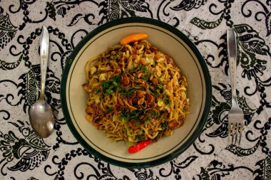 Mie Goreng Jawa ya da bakmi jawa ya da çatal kaşıklı Java noodle. Endonezya geleneksel sokak eriştesi Orta Java ya da Yogyakarta, Endonezya ahşap arka planda.