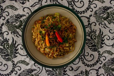 Mie Goreng Jawa ya da bakmi jawa ya da çatal kaşıklı Java noodle. Endonezya geleneksel sokak eriştesi Orta Java ya da Yogyakarta, Endonezya ahşap arka planda.