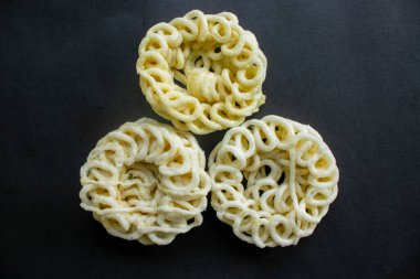 Kerupuk ya da krupuk ya da siyah arka planda izole edilmiş krakerler. Kerupuk, muhallebi hamurundan yapılan karides veya balık gibi tatlarla karıştırılmış abur cuburdur. Endonezya 'dan geleneksel atıştırmalıklar