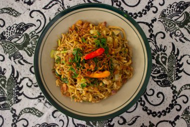 Mie Goreng Jawa ya da bakmi jawa ya da çatal kaşıklı Java noodle. Endonezya geleneksel sokak eriştesi Orta Java ya da Yogyakarta, Endonezya ahşap arka planda.