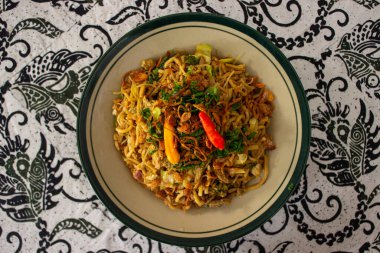 Mie Goreng Jawa ya da bakmi jawa ya da çatal kaşıklı Java noodle. Endonezya geleneksel sokak eriştesi Orta Java ya da Yogyakarta, Endonezya ahşap arka planda.