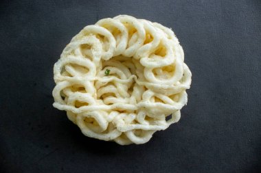 Kerupuk ya da krupuk ya da siyah arka planda izole edilmiş krakerler. Kerupuk, muhallebi hamurundan yapılan karides veya balık gibi tatlarla karıştırılmış abur cuburdur. Endonezya 'dan geleneksel atıştırmalıklar