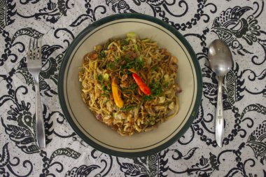 Mie Goreng Jawa ya da bakmi jawa ya da çatal kaşıklı Java noodle. Endonezya geleneksel sokak eriştesi Orta Java ya da Yogyakarta, Endonezya ahşap arka planda.