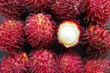 Rambutan, tatlı kırmızı rambutan meyvesi siyah arka planda izole edilmiş.