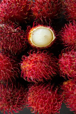 Rambutan, tatlı kırmızı rambutan meyvesi siyah arka planda izole edilmiş.