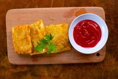 Fried Risoles or Risol Mayo are Indonesian snacks. Like Coxinha de Galinha. served with chili sauce, celery on wood board