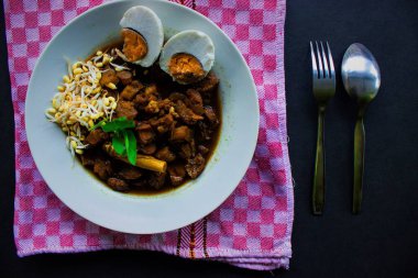 Rawon veya Nasi Rawon / Rawon Rice, Endonezya 'nın geleneksel siyah lahanalı, tuzlu yumurtalı ve kluwek soslu et çorbası. Doğu Cava 'dan. Siyah arkaplanda izole