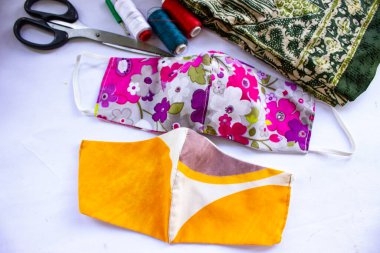 Beyaz arka planda izole edilmiş pamuk kumaş desenli el yapımı el sanatları içeren kumaş maske ya da kumaş yüz maskesi. Bu hijyenik maske, ağzını kapamak ve güzel bir dikiş modayla korunmak için..