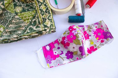 Beyaz arka planda izole edilmiş pamuk kumaş desenli el yapımı el sanatları içeren kumaş maske ya da kumaş yüz maskesi. Bu hijyenik maske, ağzını kapamak ve güzel bir dikiş modayla korunmak için..