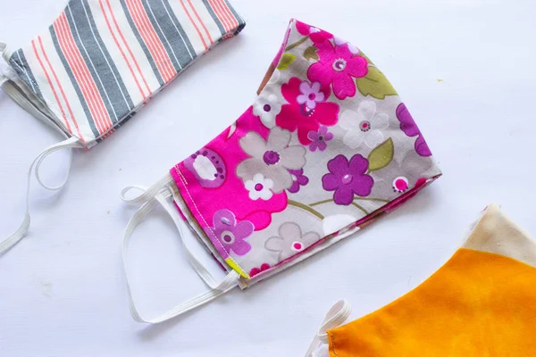 cloth mask or fabric face mask with cotton fabric flower pattern handmade crafts isolated on white background. This hygienic mask for cover mouth and protection with beautiful sewing fashion.