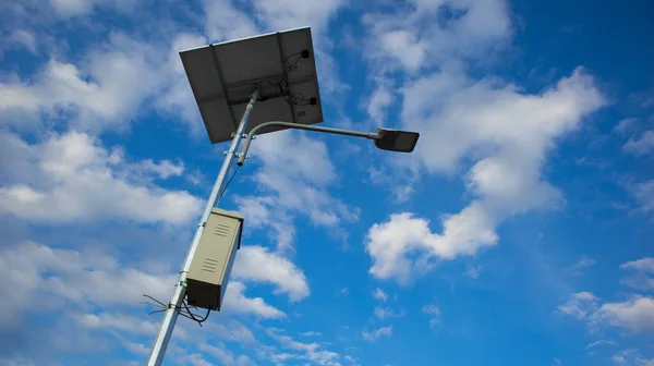 Solar-powered motion sensor light blue cloud sky background, selective focus. Clean energy.