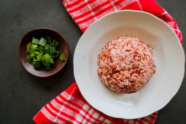 Siyah arka planda servis edilen kırmızı pilav ya da nasi merah.