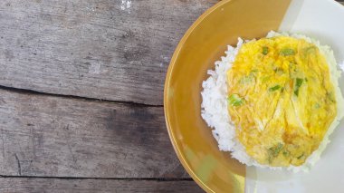 Kızarmış yumurta omleti ve pilav. Kahvaltı yumurtalı omlet pilavı tabakta, ahşap arka planda izole edilmiş.