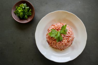 Siyah arka planda servis edilen kırmızı pilav ya da nasi merah.