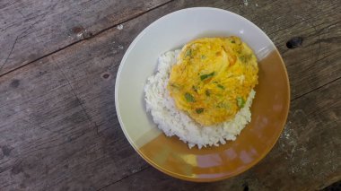 Kızarmış yumurta omleti ve pilav. Kahvaltı yumurtalı omlet pilavı tabakta, ahşap arka planda izole edilmiş.