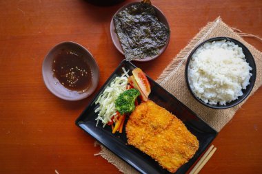 chicken katsu don is japanese food served with soy sauce on table