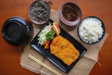 chicken katsu don is japanese food served with soy sauce on table