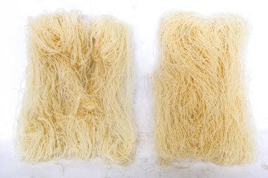 Çiğ kuru bihun veya vermicelli veya pirinç eriştesi veya beyaz arka planda izole edilmiş melek kılı.