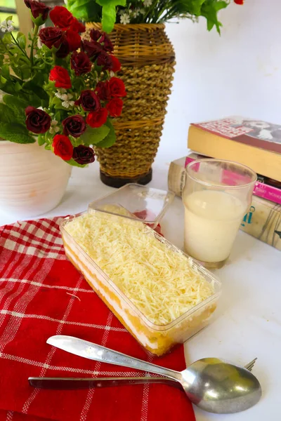 Tres Leches Cake or milk bath served with milk spoon and fork, isolated on white background