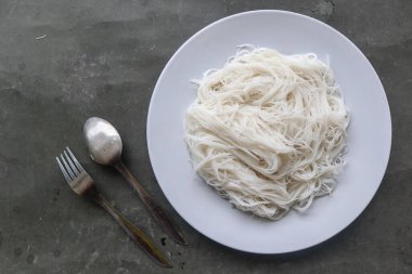 Siyah arka planda servis edilen tabakta bihun veya vermicelli veya pirinç eriştesi veya melek kılı.
