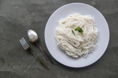 Siyah arka planda servis edilen tabakta bihun veya vermicelli veya pirinç eriştesi veya melek kılı.