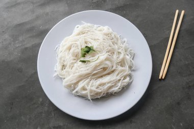 Siyah arka planda servis edilen tabakta bihun veya vermicelli veya pirinç eriştesi veya melek kılı.