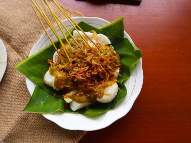 Sate Padang veya satay padang, Padang, Batı Sumatra 'dan baharatlı sığır eti satayıdır. Baharatlı köri sosu ve pirinç keki ile servis edilir, muz yaprağının üzerinde uzun süre. beyaz arkaplanda izole